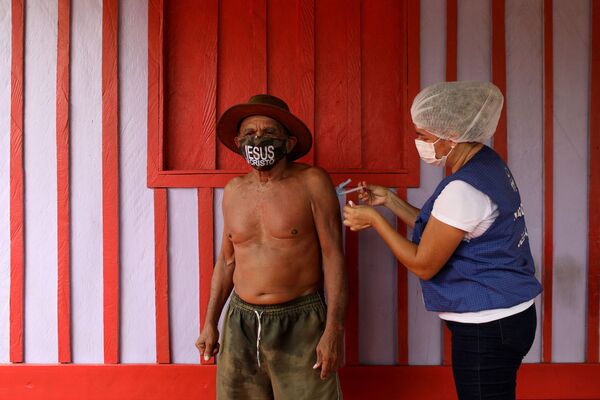 巴西內格雷河岸邊，醫務工作者阿娜•卡西亞•奧利維拉•德•利馬在接種日當天，給75歲老人喬奧•阿基諾•菲略注射阿斯利康（AstraZeneca）疫苗。 - 俄羅斯衛星通訊社