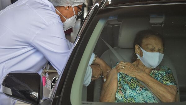 Женщина получает дозу вакцины Coronavac в проезде через центр вакцинации на стадионе Pacaembu в Сан-Паулу, Бразилия - 俄罗斯卫星通讯社