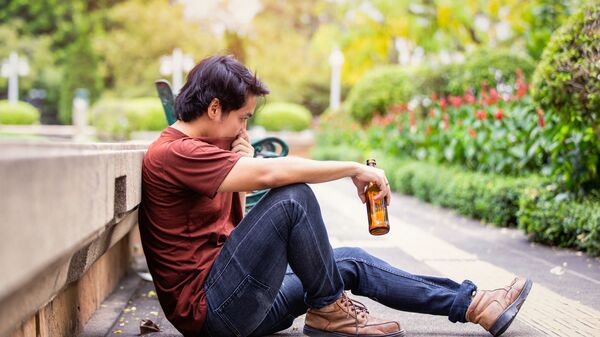 男子在公园里拿着一瓶啤酒  - 俄罗斯卫星通讯社