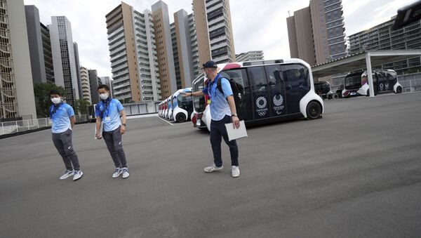 Сотрудники у электроавтобусов в Олимпийской и Паралимпийской деревне в Токио - 俄罗斯卫星通讯社