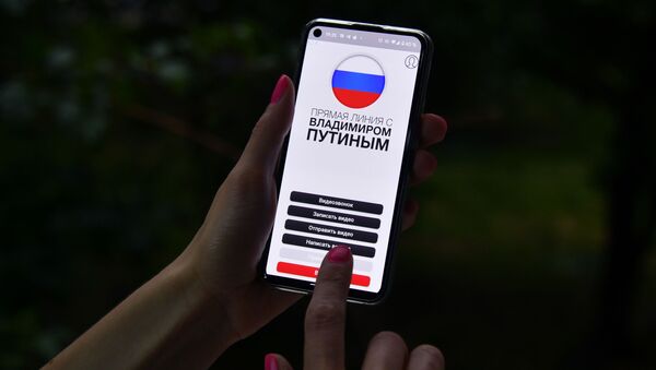 Девушка держит в руке смартфон с открытым мобильным приложением Москва-Путину - 俄羅斯衛星通訊社