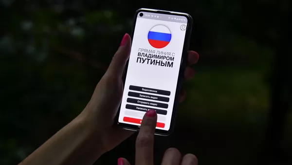 Девушка держит в руке смартфон с открытым мобильным приложением Москва-Путину - 俄罗斯卫星通讯社