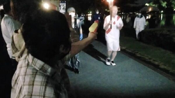 Японка пыталась потушить олимпийский огонь Токио-2020 водяным пистолетом в знак протеста - 俄羅斯衛星通訊社