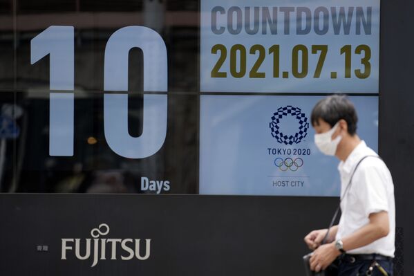 一名戴口罩男子路过2020年东京奥运会开幕倒计时的海报 - 俄罗斯卫星通讯社