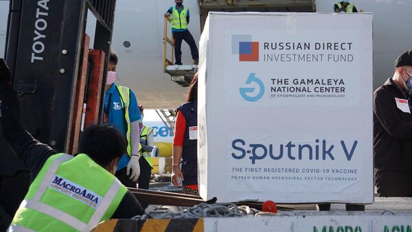Рабочие, выгружающие первую партию вакцины от коронавируса Sputnik V российского производства в аэропорту Манилы - 俄罗斯卫星通讯社
