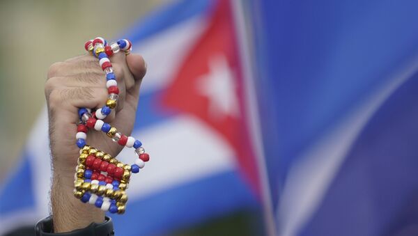 Демонстрант держит в руках ожерелье в Майями во время акции в поддержку антиправительственных выступлений на Кубе - 俄羅斯衛星通訊社