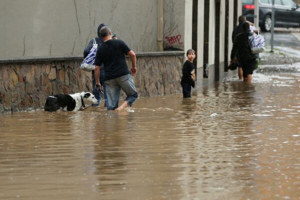Люди идут по затопленной улице после проливных дождей в Хагене, Германия - 俄羅斯衛星通訊社