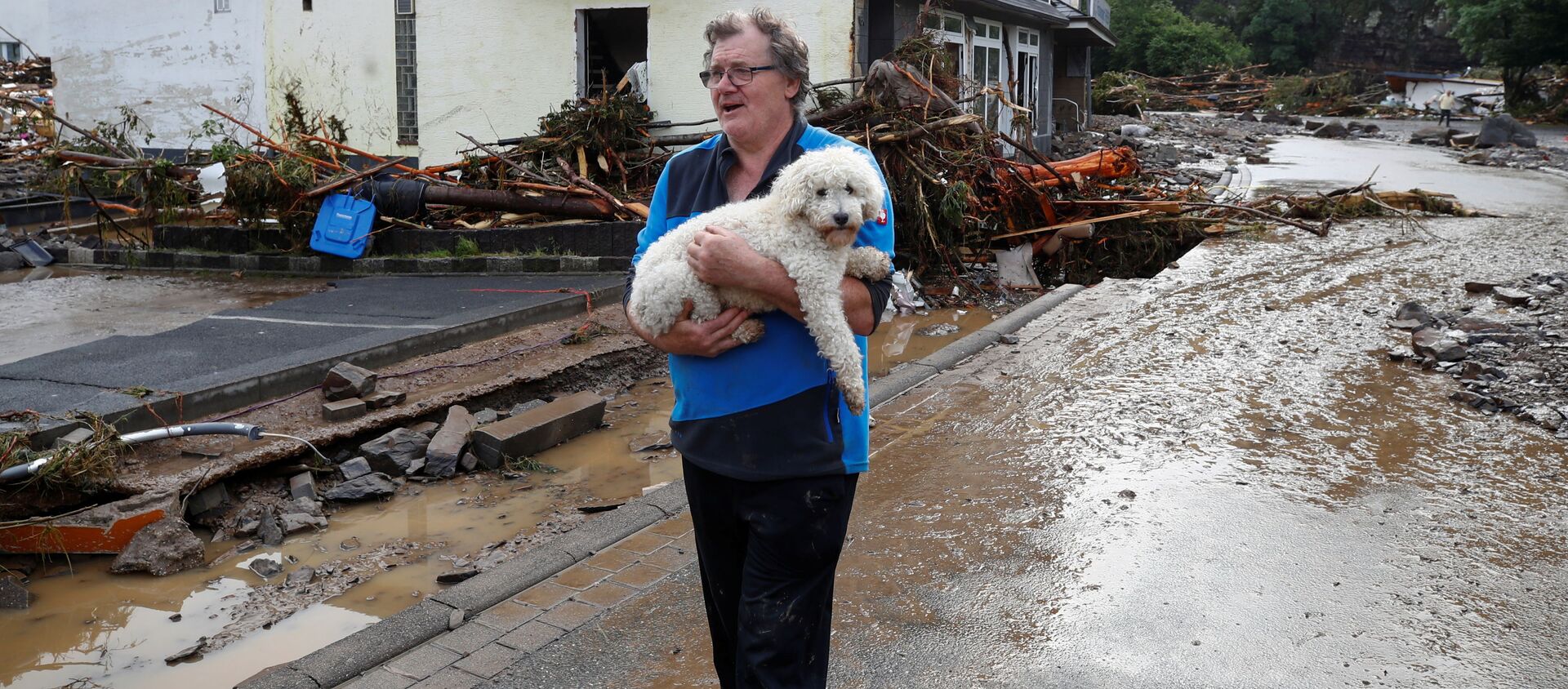 Мужчина с собакой на затопленной и заваленной ветками улице в Шульде, Германия, 15 июля 2021 года. - 俄羅斯衛星通訊社, 1920, 19.07.2021