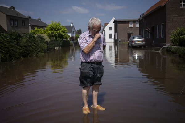 荷兰，一名男子站在自家房屋附近被洪水淹没的街上。 - 俄罗斯卫星通讯社