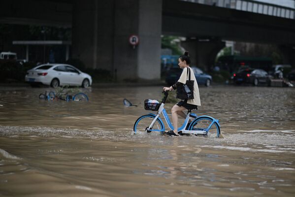 河南居民在大水淹沒的街道上騎行。 - 俄羅斯衛星通訊社