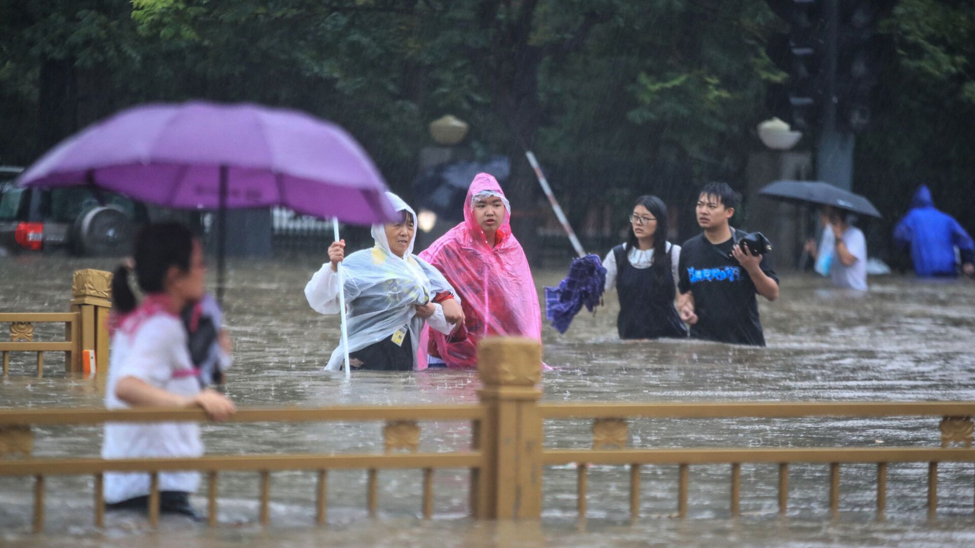 На этой фотографии, сделанной 20 июля 2021 года, показаны люди, пробирающиеся через паводковые воды по улице после проливных дождей в Чжэнчжоу в центральной провинции Китая Хэнань. - 俄罗斯卫星通讯社, 1920, 23.07.2021