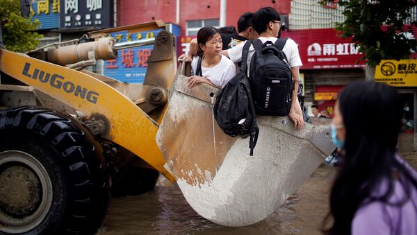 Люди, едущие на фронтальном погрузчике, после проливного дождя в Чжэнчжоу, Китай - 俄羅斯衛星通訊社