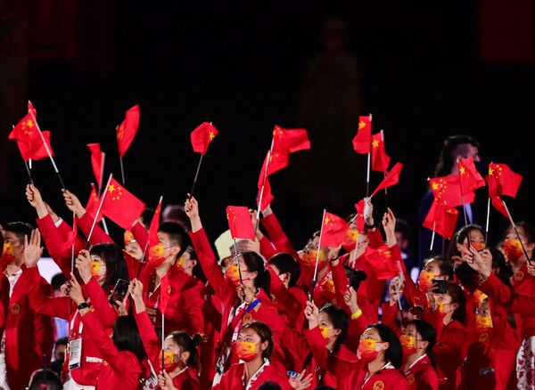 Члены китайской делегации машут флагами, входя на Олимпийский стадион во время церемонии открытия в Токио - 俄罗斯卫星通讯社