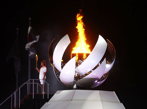 Наоми Осака из Японии держит олимпийский факел после зажжения олимпийского котла на церемонии открытия  - 俄罗斯卫星通讯社