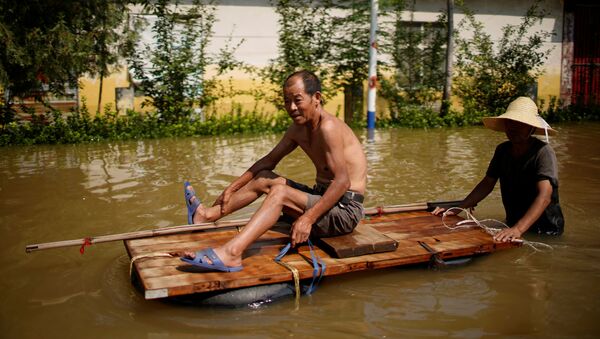 Жители деревни пробираются через паводковые воды после проливных дождей в деревне в Синьсяне, провинция Хэнань, Китай - 俄羅斯衛星通訊社