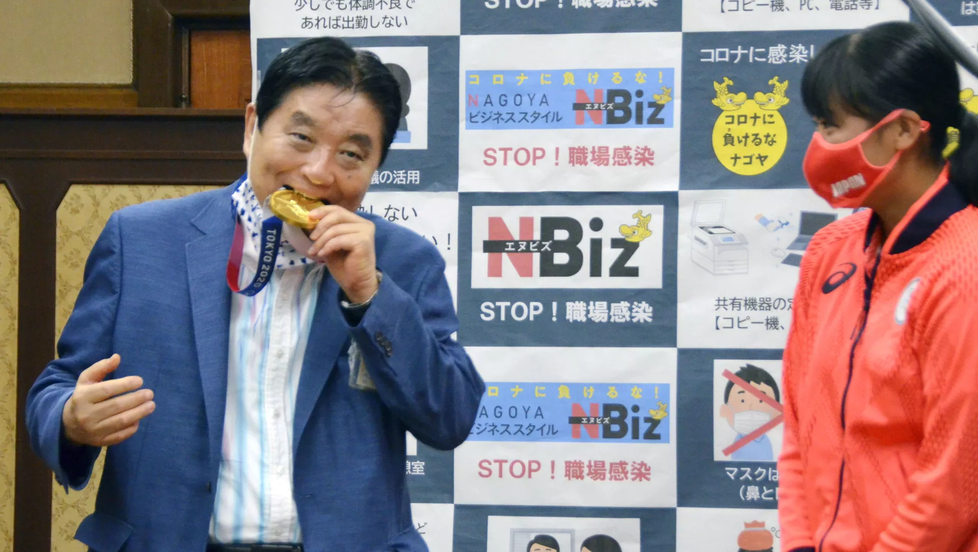 Nagoya city Mayor Takashi Kawamura bites the Tokyo 2020 Olympic Games gold medal 