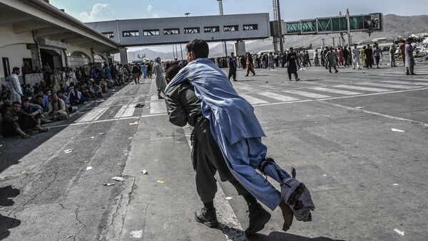 Волонтер с раненым афганцем в аэропорту Кабула  - 俄罗斯卫星通讯社