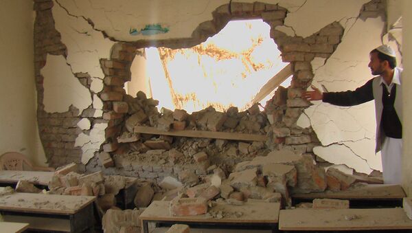 An Afghan man shows a destroyed class room after it was blown up with explosives in Mandozai, in Khost province, Afghanistan, Wednesday, Nov 19, 2008. Chief education officer of Khost province stated that the school was destroyed using explosives by the enemies of Afghanistan.(AP Photo/Nashanuddin Khan) - 俄羅斯衛星通訊社