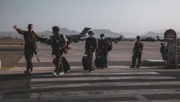 Морской пехотинец, прикомандированный к 24-му экспедиционному отряду морской пехоты, сопровождает персонал Государственного департамента для подготовки к эвакуации в международном аэропорту Хамида Карзая в Кабуле, Афганистан - 俄罗斯卫星通讯社