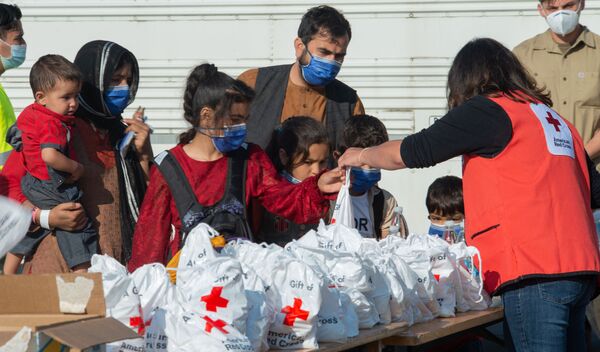 红十字会代表在德国拉姆施泰因空军基地向阿富汗撤离人员分发援助物资。 - 俄罗斯卫星通讯社