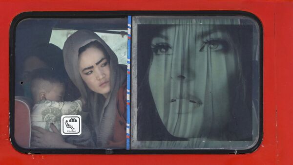 伊朗-阿富汗邊境的一輛公共汽車上，一名抱著孩子的阿富汗婦女。 - 俄羅斯衛星通訊社