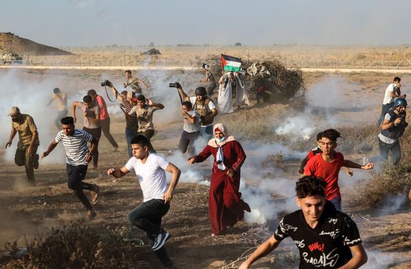 加沙地带南部的抗议活动中，巴勒斯坦的示威者和记者们正在逃离催泪瓦斯。 - 俄罗斯卫星通讯社