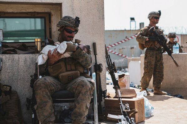 阿富汗喀布尔国际机场，一名美国海军陆战队队员在撤离时怀抱着一个婴儿。 - 俄罗斯卫星通讯社