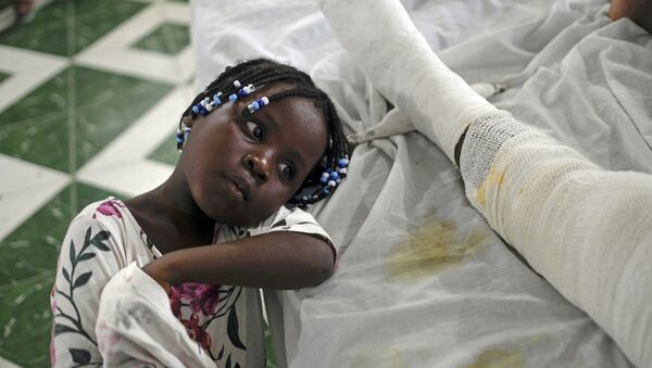 Юнаика в больнице рядом со своей матерью, пострадавшей в результате землетрясения  Ле-Ке, Гаити - 俄罗斯卫星通讯社