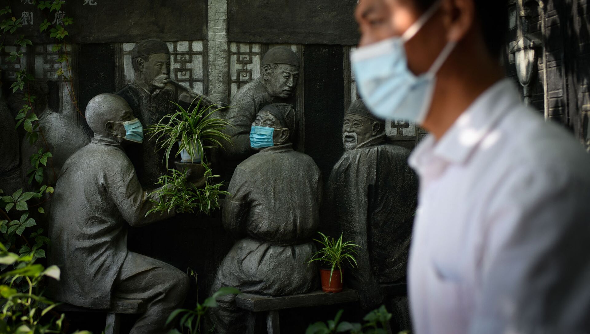 Мужчина проходит мимо скульптур в масках возле ресторана в Пекине - 俄罗斯卫星通讯社, 1920, 19.09.2021