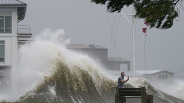 Мужчина фотографирует высокие волны на берегу озера Пончартрейн во время приближения урагана Ида в Новом Орлеане - 俄羅斯衛星通訊社
