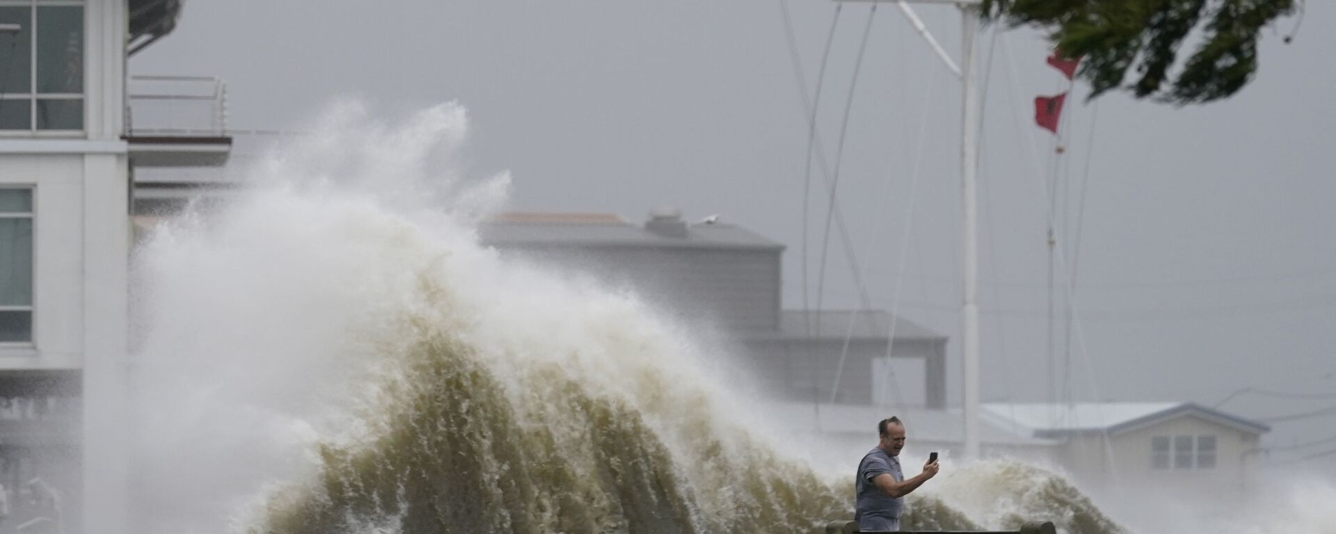 Мужчина фотографирует высокие волны на берегу озера Пончартрейн во время приближения урагана Ида в Новом Орлеане - 俄罗斯卫星通讯社, 1920, 30.08.2023