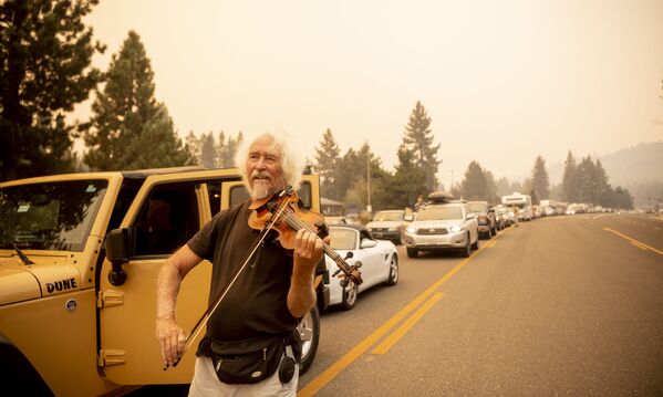 梅尔•斯莫特斯在加利福尼亚公路上为疏散居民演奏小提琴。 - 俄罗斯卫星通讯社