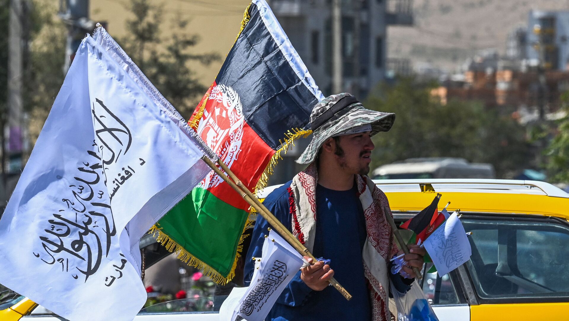 Мужчина продает государственный флаг Афганистана и флаг Талибана на улице Кабула - 俄罗斯卫星通讯社, 1920, 13.10.2021