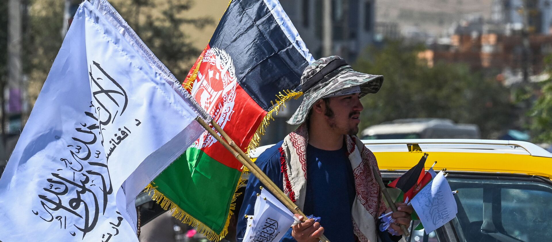 Мужчина продает государственный флаг Афганистана и флаг Талибана на улице Кабула - 俄羅斯衛星通訊社, 1920, 24.09.2021