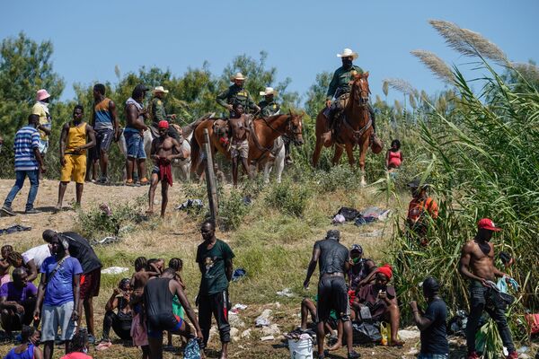 美國邊境騎警試圖阻止海地移民進入德克薩斯州德爾里奧市格蘭德河岸營地。 - 俄羅斯衛星通訊社