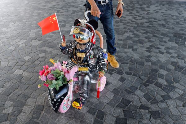 A pro-China supporter pushes a doll with Chinese flag on Chinese National Day, in Hong Kong, China, October 1, 2021.  - 俄罗斯卫星通讯社