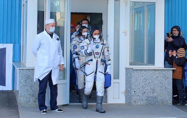 This handout photo taken and released on October 5, 2021 by Russian Space Agency Roscosmos shows crew members, cosmonaut Anton Shkaplerov (first), actress Yulia Peresild (second) and film director Klim Shipenko walking to board the Soyuz MS-19 spacecraft prior to its launch at the Russian-leased Baikonur cosmodrome. - Russia on October 5, 2021 is set to launch an actress and a film director into space in a bid to best the United States to the first movie in orbit.  - 俄羅斯衛星通訊社