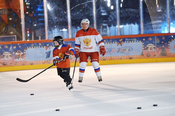 俄罗斯总统弗拉基米尔·普京与“心愿枞树”慈善活动9岁参与者德米特里·阿谢普科夫一起在古姆商场冰场进行冰球训练，2020年12月21日 - 俄罗斯卫星通讯社