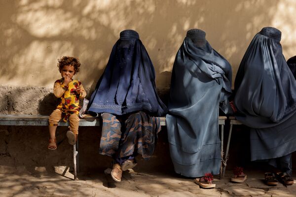 喀布爾一家醫院附近，一個小女孩和幾個身著布爾卡長袍的女子坐在一起。 - 俄羅斯衛星通訊社