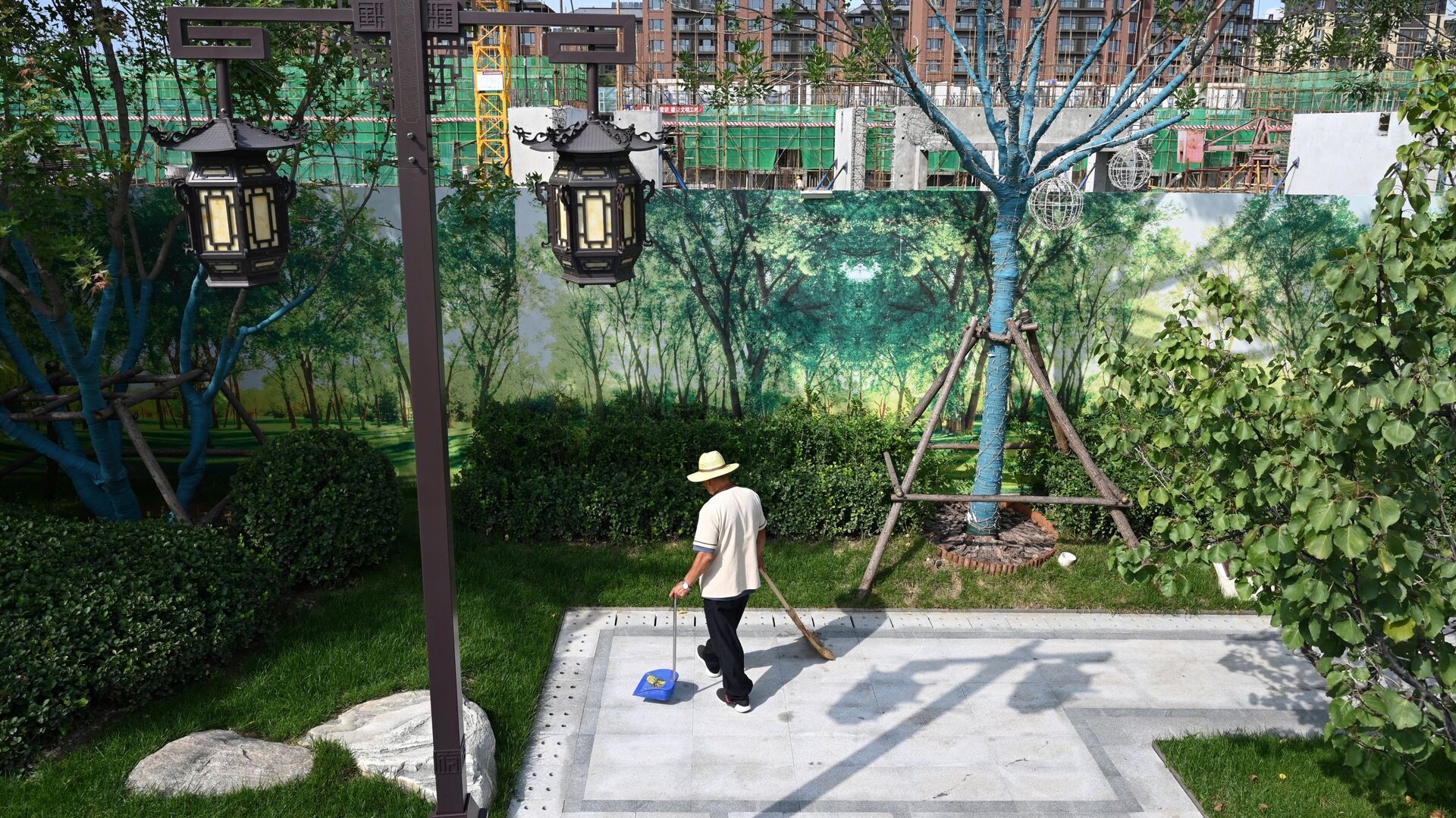 A worker cleans a display area next to the construction site of an Evergrande housing complex in Beijing on September 13, 2021 - 俄罗斯卫星通讯社, 1920, 08.10.2021