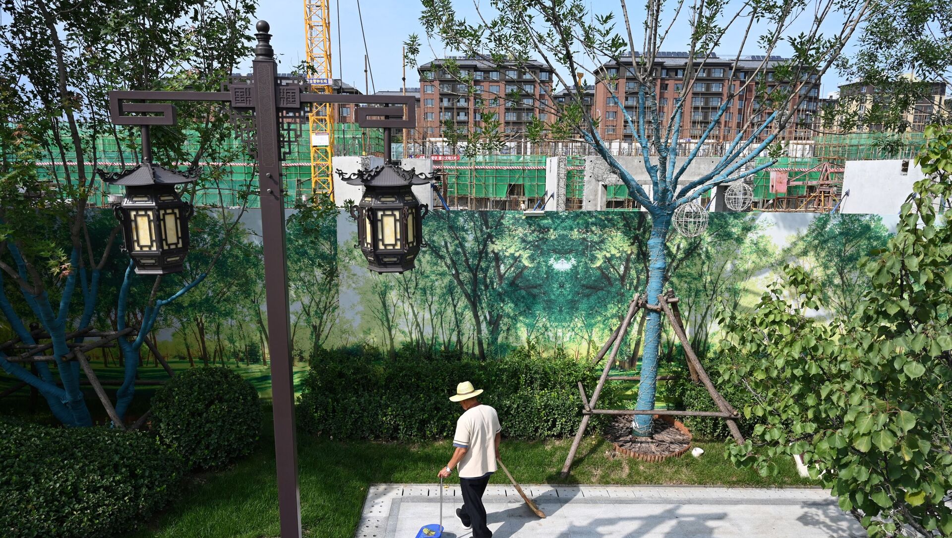A worker cleans a display area next to the construction site of an Evergrande housing complex in Beijing on September 13, 2021 - 俄羅斯衛星通訊社, 1920, 08.10.2021
