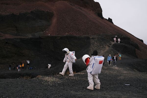 內蒙古烏蘭哈達火山群6號火山附近身著宇航員服裝的遊客們。 - 俄羅斯衛星通訊社