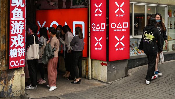 Покупатели в небольшом магазине хрустящих леденцов далгонас, показанных в сериале Netflix Squid Game, в Шанхае - 俄羅斯衛星通訊社