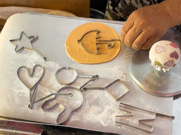 街边小贩正在制作《鱿鱼游戏》电影主题的伞型糖饼。 - 俄罗斯卫星通讯社