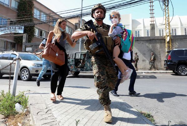 當和平居民因利比亞貝魯特槍戰逃離時抱著一名學生的軍人。 - 俄羅斯衛星通訊社