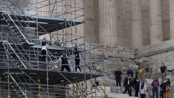 Security staff try to take a banner from protesters on scaffolding at the Acropolis hill, in Athens - 俄羅斯衛星通訊社