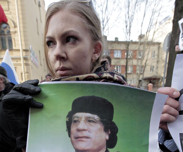 2011年，美國駐聖彼得堡總領事館外，一位姑娘手持卡扎菲肖像參加反對外國勢力介入利比亞的示威活動。 - 俄羅斯衛星通訊社