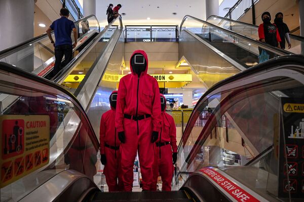 馬來西亞吉隆坡一家購物中心的自動扶梯上的《魷魚遊戲》的角色扮演者。 - 俄羅斯衛星通訊社
