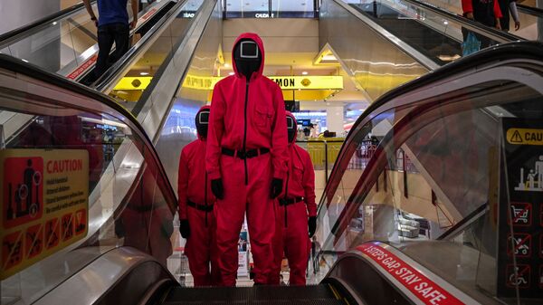 Косплееры в костюмах персонажей из сериала Netflix Игра в кальмара на эскалаторе в торговом центре Куала-Лумпура, Малайзия - 俄羅斯衛星通訊社