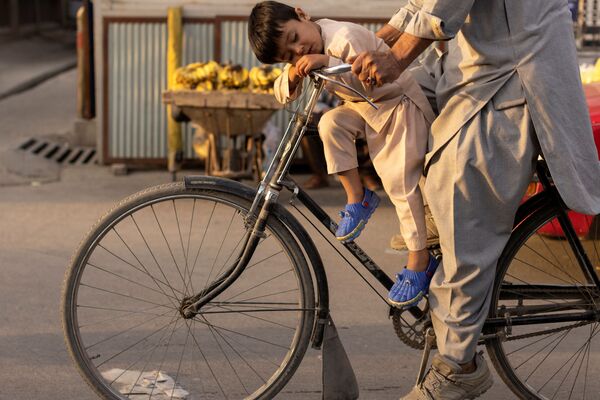 阿富汗喀布爾，一個男孩在自行車上睡著了。 - 俄羅斯衛星通訊社